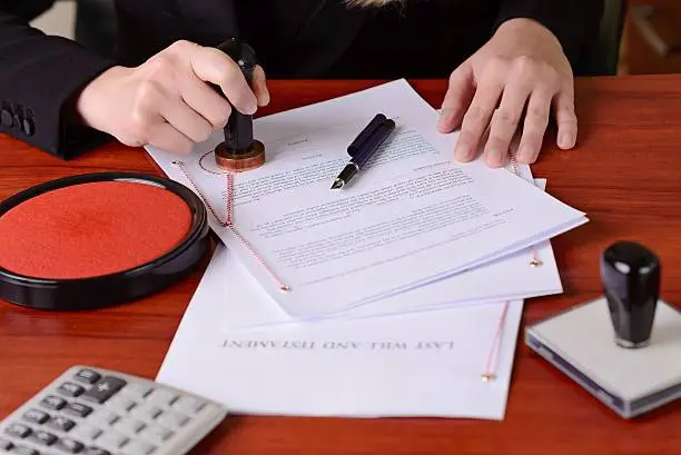 person stamping a document on a desk